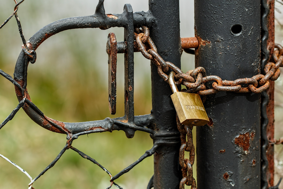The padlock of an old barbed wired gate